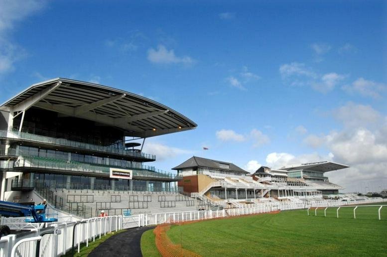 Exterior view of the grandstands at Aintree Racecourse Executive Box under a blue sky.