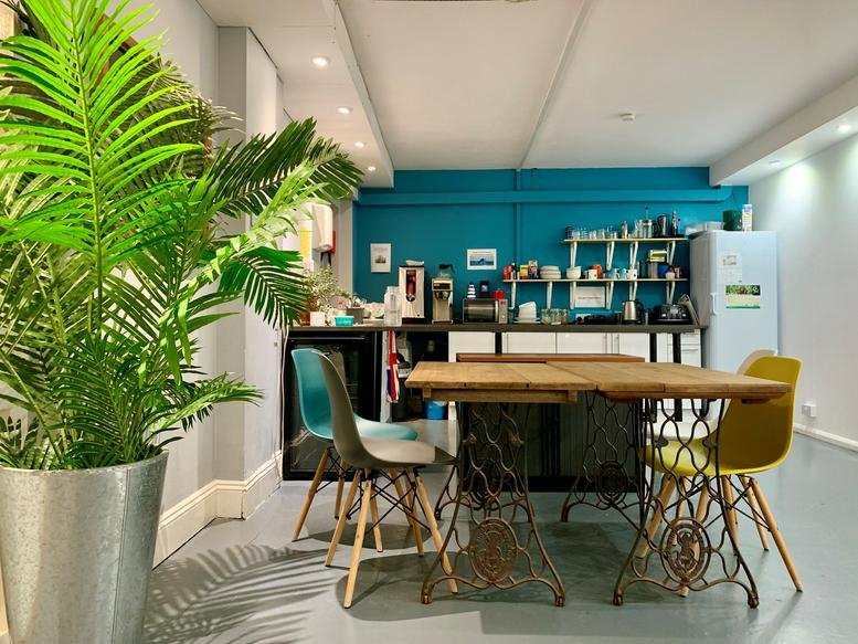 Spacious communal kitchen and breakout area at Palmeira Square, Hove, East Sussex with vibrant teal walls.