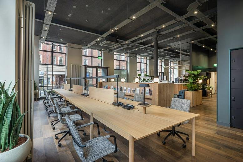 Spacious open-plan workspace at Park House, Park Square West with wooden desks and industrial ceilings.