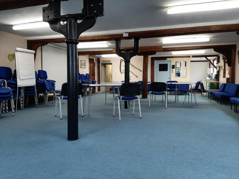 Spacious communal meeting area at Parkway, Essex, Chelmsford with blue chairs and historic dark wood beams.