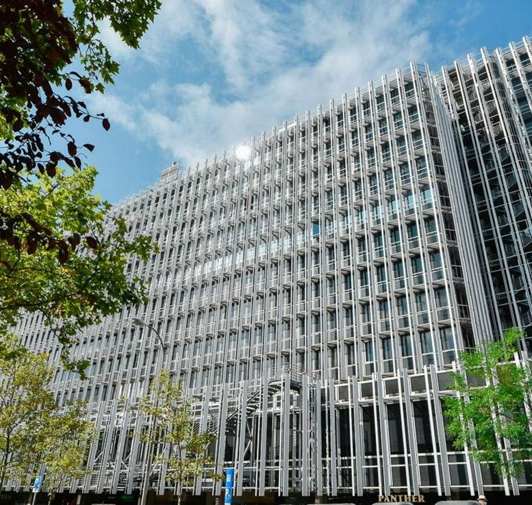 Exterior view of the modern glass-facade building at Paseo de la Castellana, 91.
