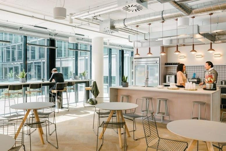 Spacious communal kitchen and lounge area at Passeig de Gràcia 17 with natural light and bar seating.