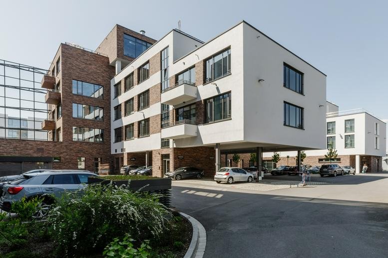 Exterior view of the modern white and brick facade at Erlangen Paul Carré.