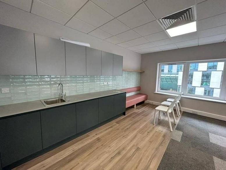 Modern communal kitchen at Pearse Street, 4 Westland Square, Dublin with grey cabinetry and light wood floors.