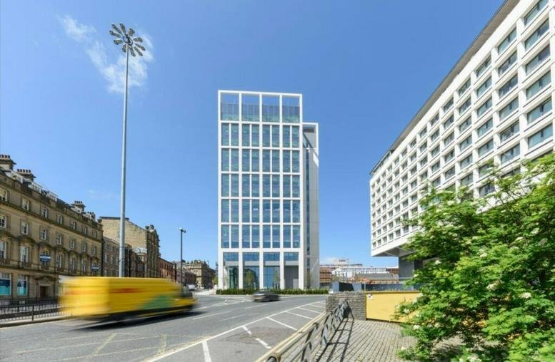 Exterior view of the modern glass-facade Bank House on Pilgrim Street under a clear blue sky.