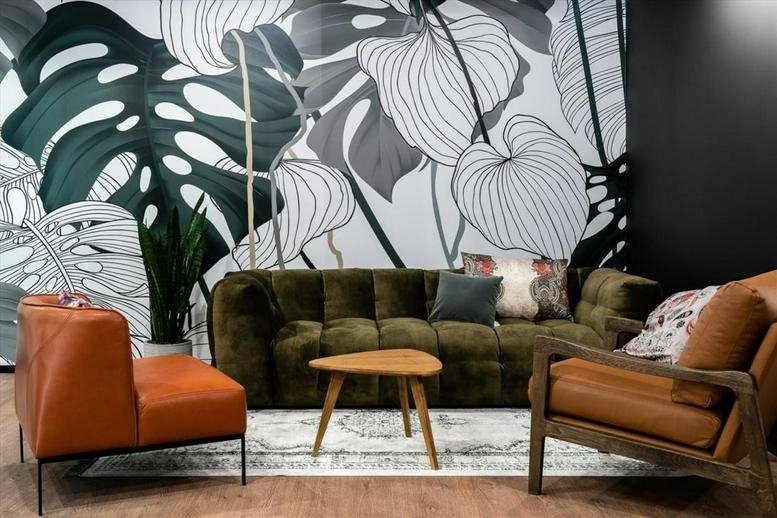 Plac Trzech Krzyży 10/14 lounge with an olive velvet sofa, tan leather chairs, and botanical mural.