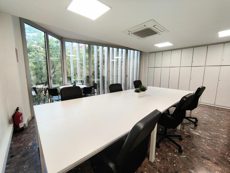 Spacious meeting room at Plaza Doctor Letamendi, 1, 2 piso, Barcelona with a large white table and garden views.
