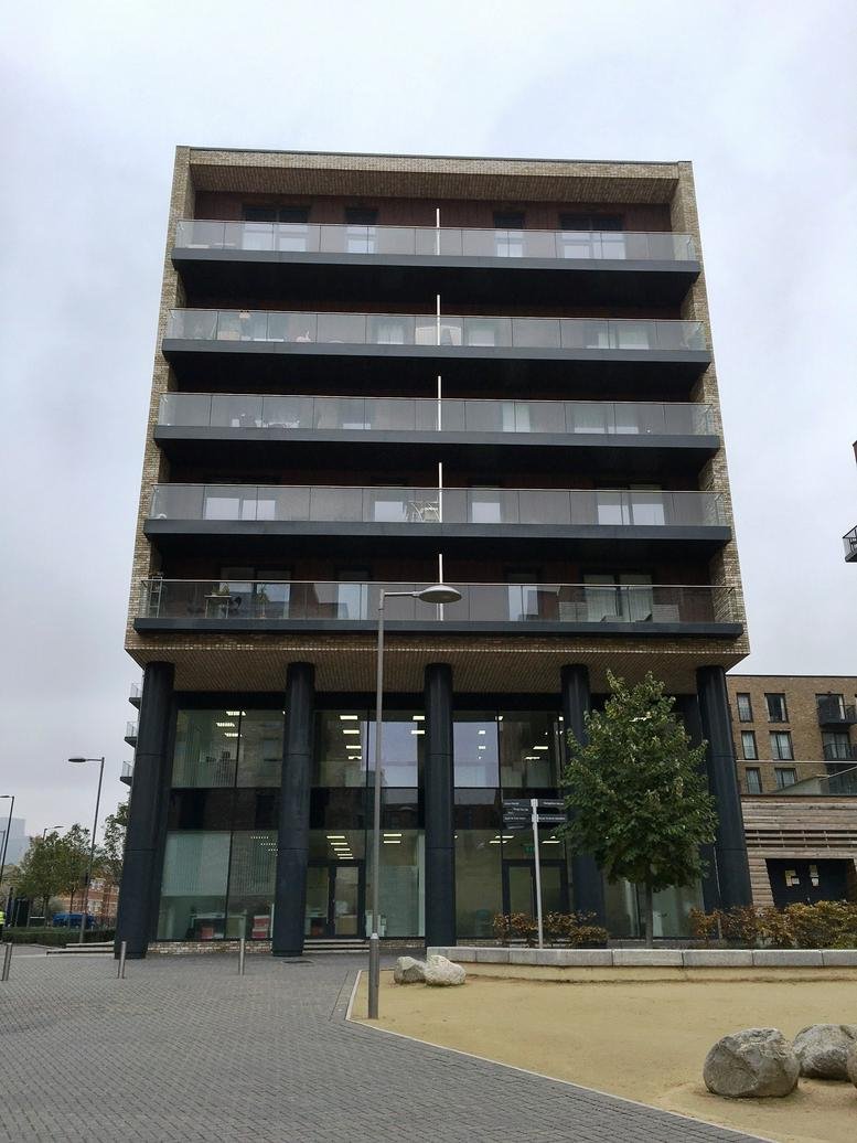 Exterior facade of Cadmus Court, Marine Wharf showing multiple balconies and large ground floor windows.