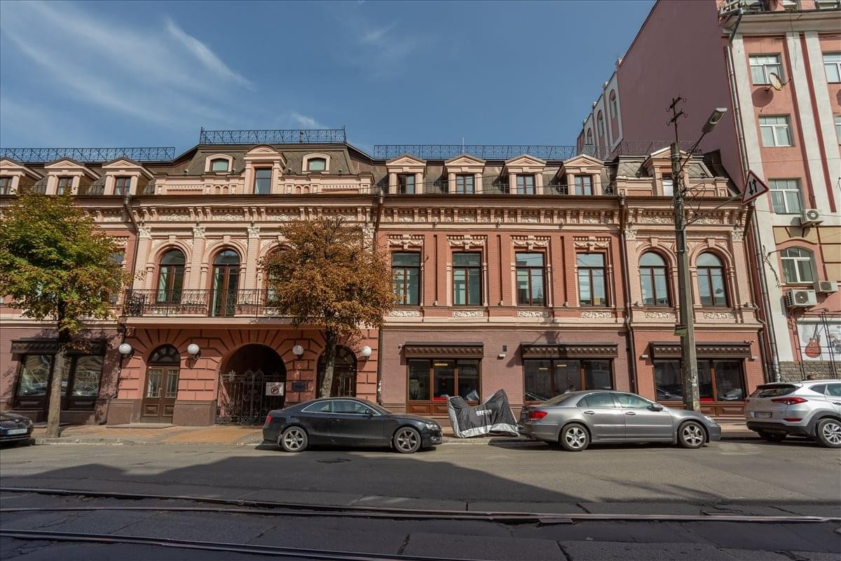 Exterior view of the historic brick facade at Podil Heritage Centre with classic dormer windows and street-level shops.