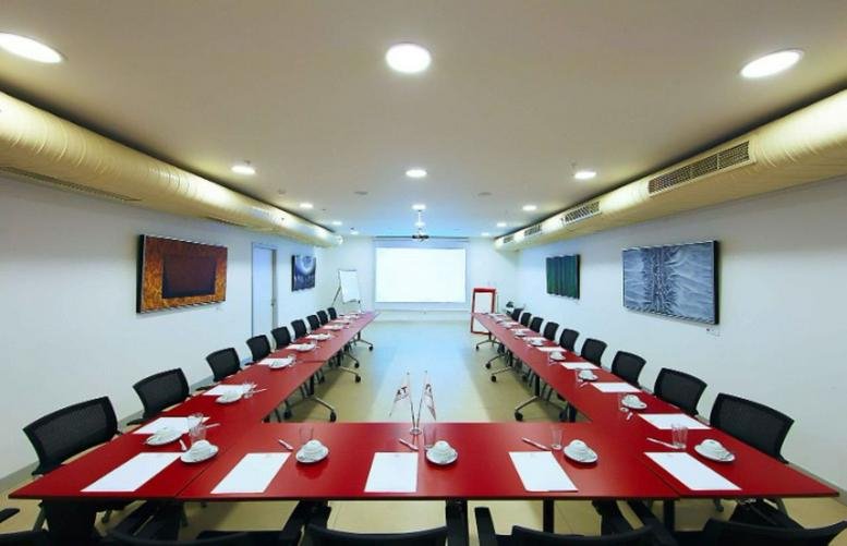 Large professional meeting room at Pol Center featuring a U-shaped red conference table.