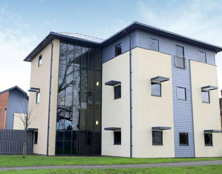 Exterior of the modern three-story Portobello House with glass atrium and light-colored facade.
