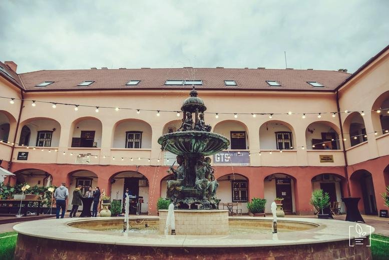Exterior view of the historic Proclamatia de la Timisoara, Number 5 building courtyard with a central fountain.