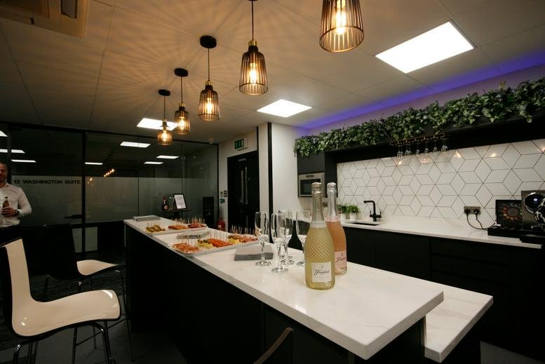 Breakout area and kitchen at Ground Floor, Prospect House, Columbus Quay, with modern pendant lighting and greenery.