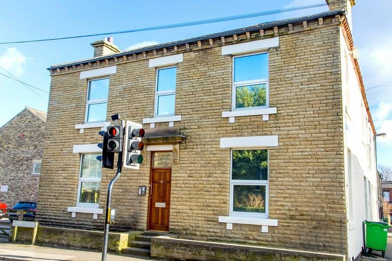 Exterior stone facade of the Prospect Road, Ossett, West Yorkshire building with large windows.