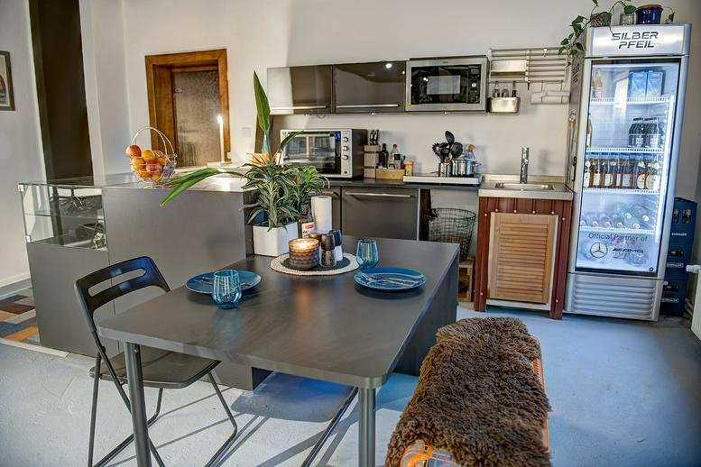 Kitchen and dining area at Provinzstrasse 57, Berlin, Brandenburg with a table and glass-door refrigerator.