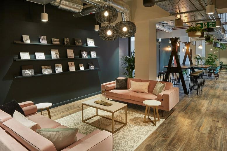 Spacious communal lounge at Quadrant House, Broad Street Mall, featuring pink sofas and a bookshelf wall.