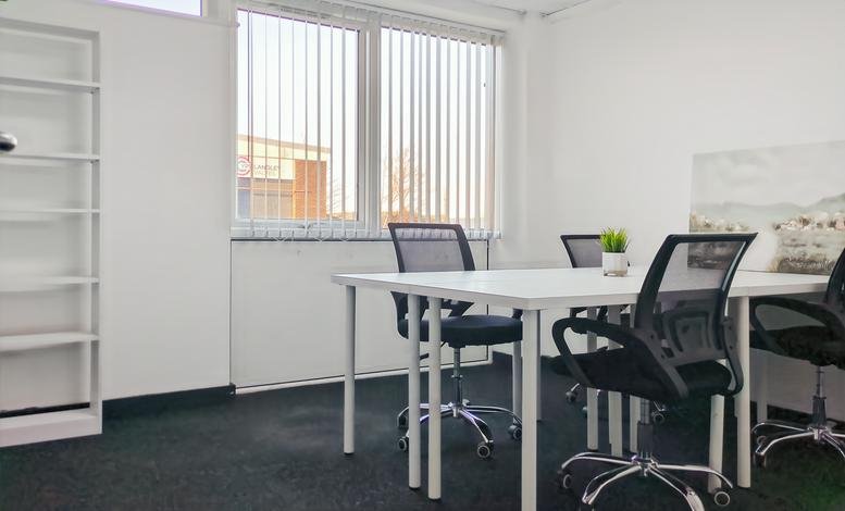 Private office with a four-desk arrangement and a white bookcase.