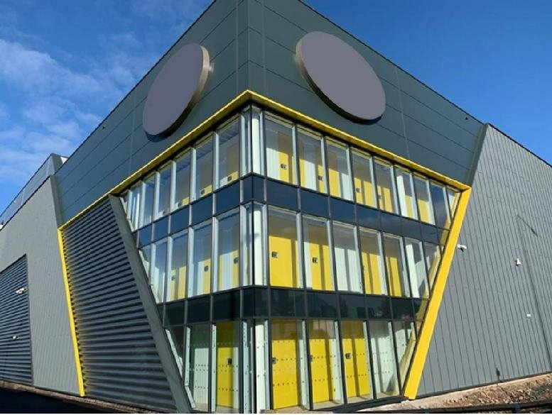 Exterior view of the modern grey and yellow facade of the Rayner Lane, Ashton-Under-Lyne, Greater Manchester building.
