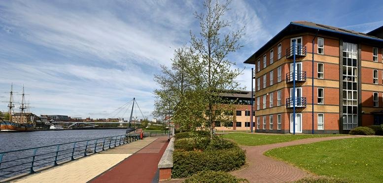 Exterior view of the brick facade at Richard House, Sorbonne Close, overlooking a calm riverside walkway.