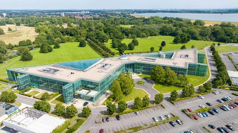 Aerial view of the glass-facade Riding Court Road building surrounded by greenery.