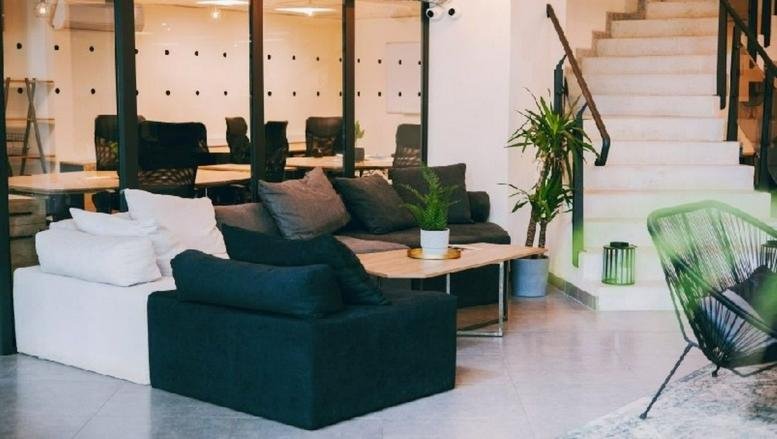 Spacious communal lounge at Ring Tower with modern sofas, a coffee table, and indoor plants.