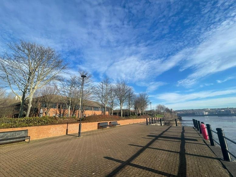 Exterior of Riverview Business Centre, Asama Court, featuring a brick building and a riverside promenade.