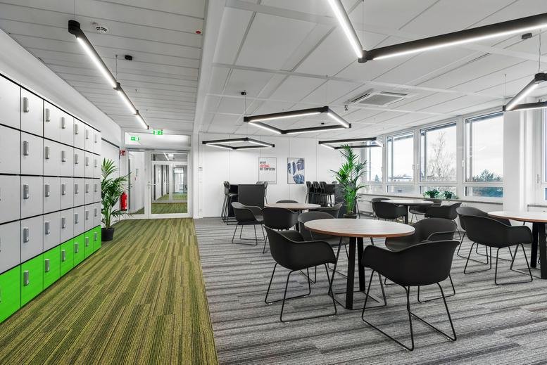 Spacious communal lounge at Robert-Bosch-Straße 5, Dreieich, Hesse with lockers and breakout tables.