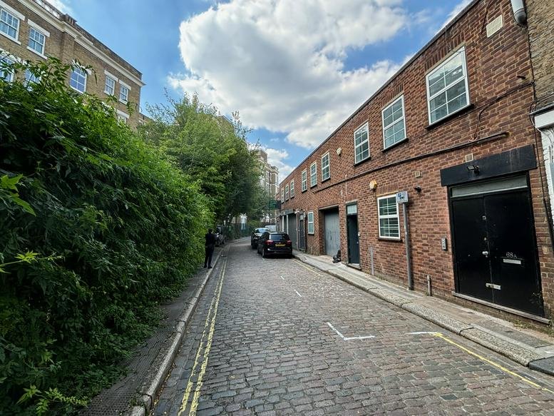 Exterior brick facade of the Rochester Place, London office building on a cobbled street.
