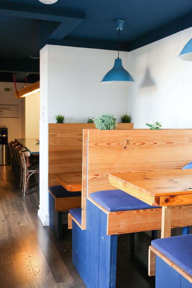 Communal dining area at Rua Filipe Folque 2, (1º Direito), featuring wood booths, blue accents, and pendant lights.