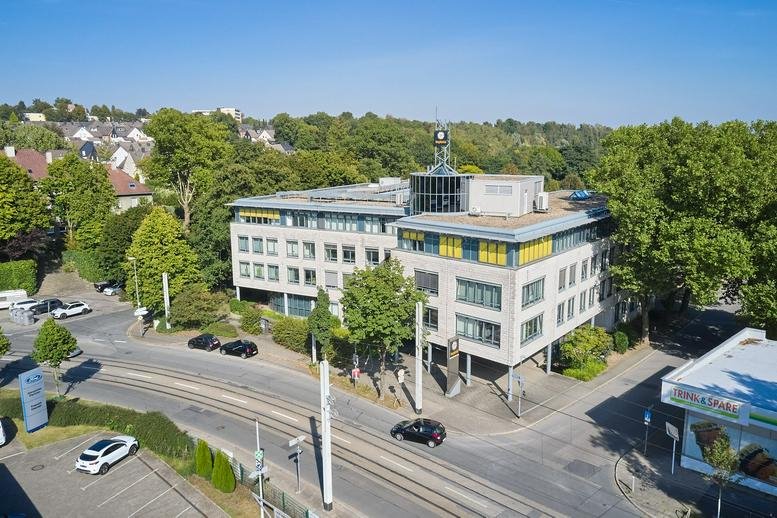 Exterior view of the office building at Schnabelstraße 1, 9-13A, 17 surrounded by lush green trees.