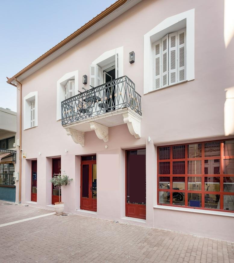 Exterior view of the light pink facade of Sfaktirias 18, Messinia, Kalamata with traditional balconies.
