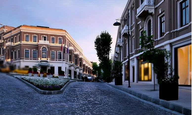 Exterior view of the historic Akaretler Sıraevler rowhouses along a cobblestone street at dusk.