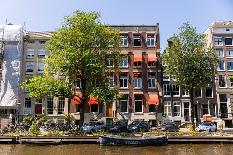 Exterior view of the traditional brick facade at Singel 126, Amsterdam, North Holland alongside a canal.