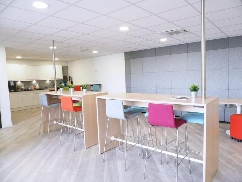 Spacious communal breakout area at Fleet House, Springhead Enterprise Park, with colorful chairs and a kitchen.