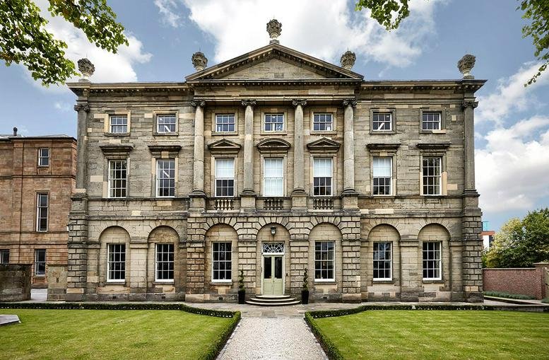 Grand Georgian exterior facade of St Helen’s House with symmetrical windows and a pediment.