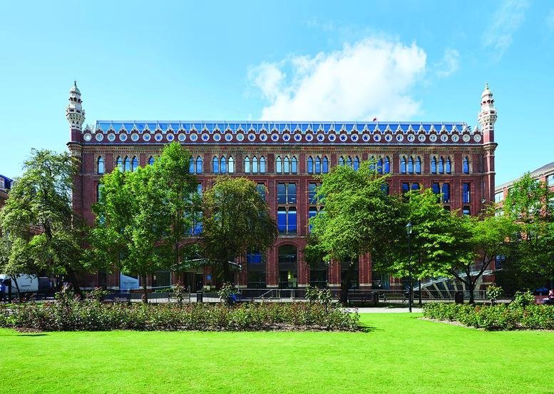 Exterior view of the ornate red brick facade of St. Paul’s House under a clear blue sky.