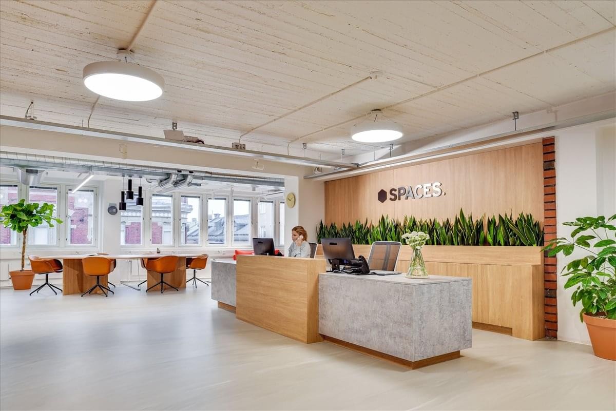 Bright reception area at Stamholmen 147-161, Hvidovre with a wooden desk, stone counter, and indoor greenery.