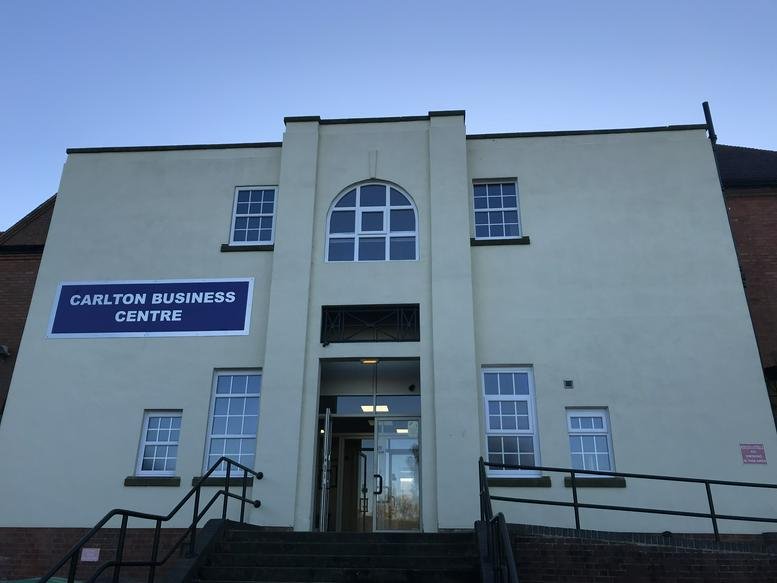 Exterior facade of the Carlton Business Centre with centered entrance and arched window.