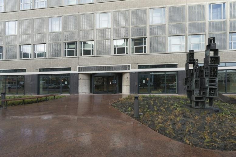 Modern stone facade and entrance of the Stations Post Offices, Waldorpstraat 5 building.