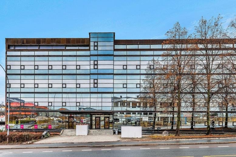 Exterior view of the modern glass-facade building at Østensjøveien 43, Oslo, Norway.