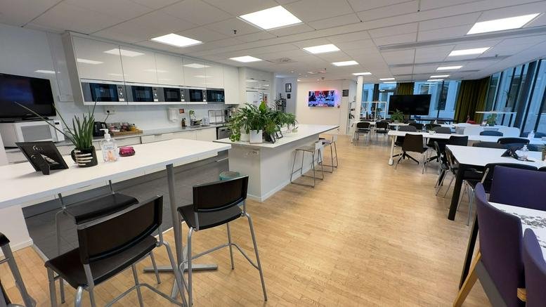 Wide-angle view of the modern cafe and communal dining area at Östgötagatan 12, Stockholm.