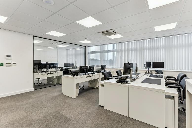 Spacious open-plan office at Stirling Way, Borehamwood, Hertfordshire with white desks and glass partitions.