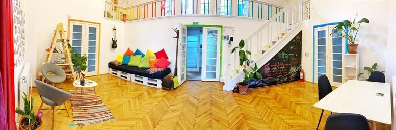 Spacious communal lounge at The Garden, Strada Virgil Madgearu 5 featuring a pallet sofa and mezzanine level.