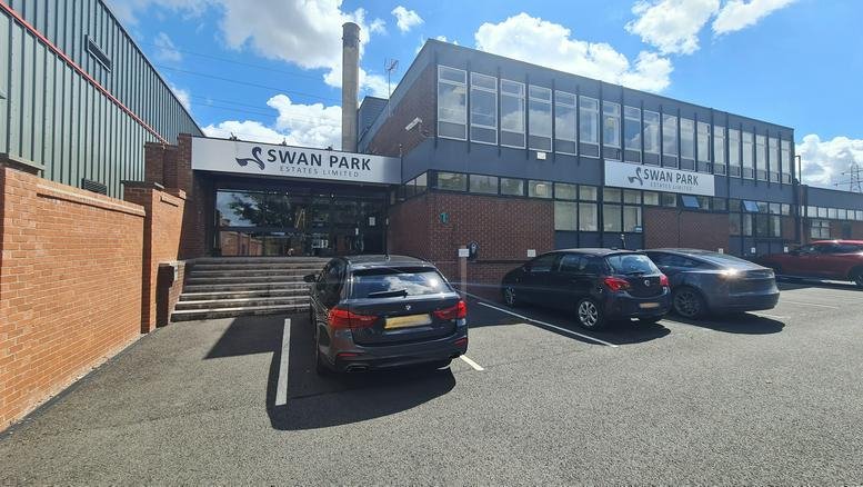 Exterior facade of the Swan Park Business Centre featuring brickwork and a large windowed entrance.
