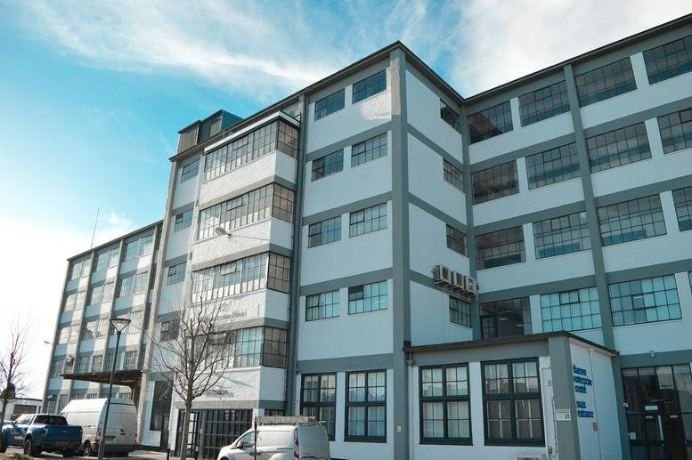 Exterior of Thames Enterprise Centre Building 13 showing its multi-story industrial facade under a blue sky.