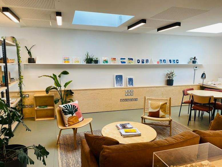 Bright breakout lounge at Thane Studios, 2, 4 Thane Villas, featuring wood furniture, plants, and a sofa.