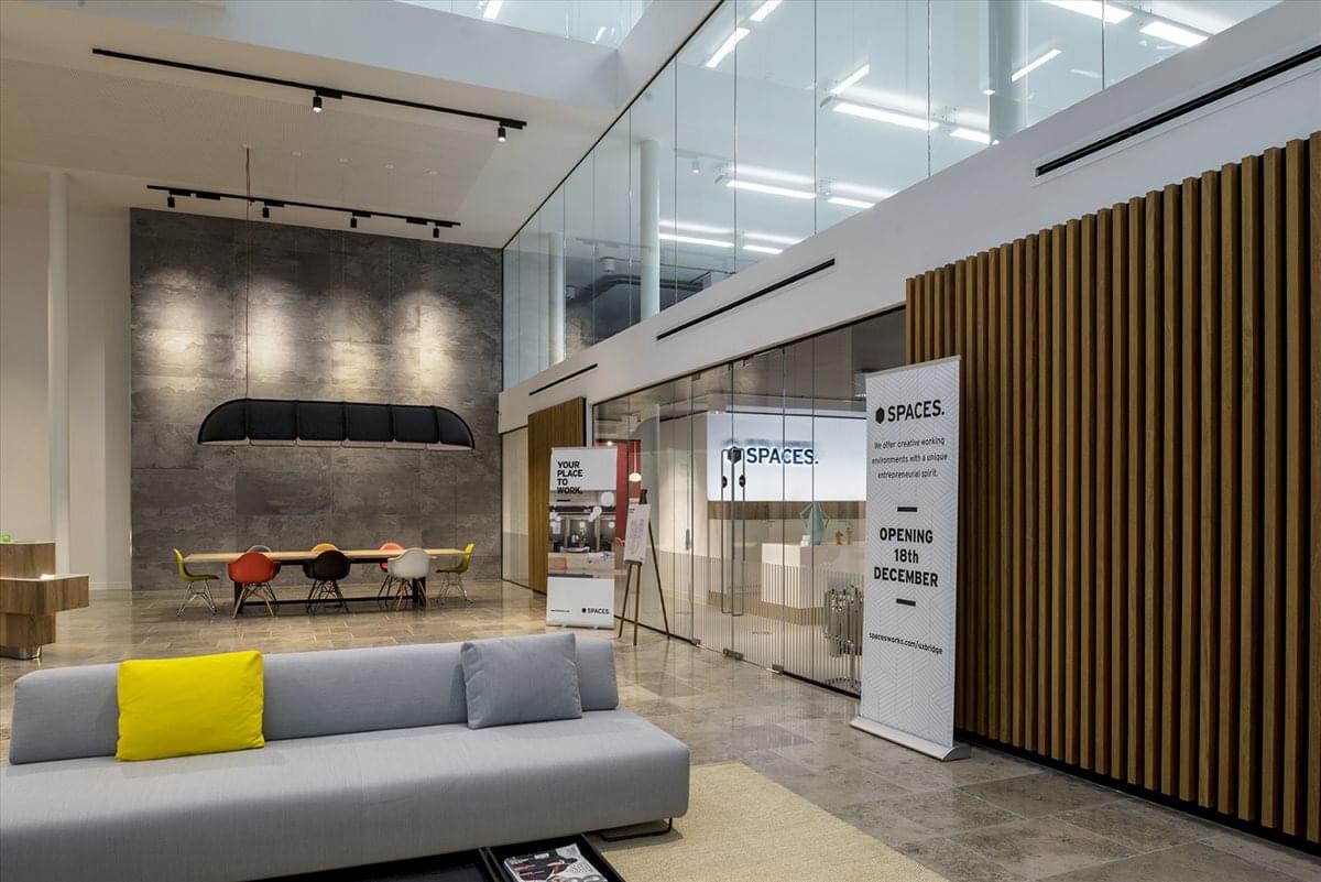 Double-height lobby at The Charter Building, Charter Place, Uxbridge with a large grey feature wall.