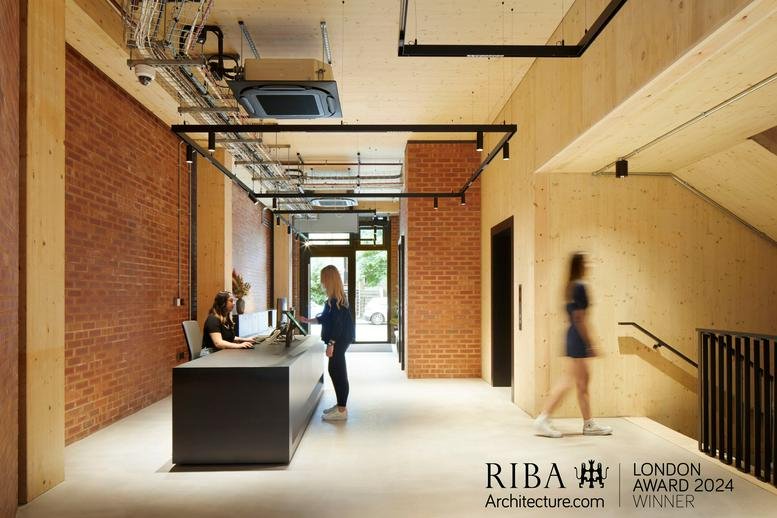Reception area at The Department Store Studios with brick walls, timber ceilings and a long black desk.