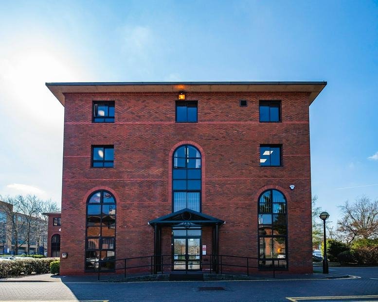 Full brick exterior of the building under a clear blue sky.