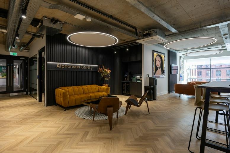 Spacious lounge and reception area at The Linenhall with a yellow sofa and modern art.